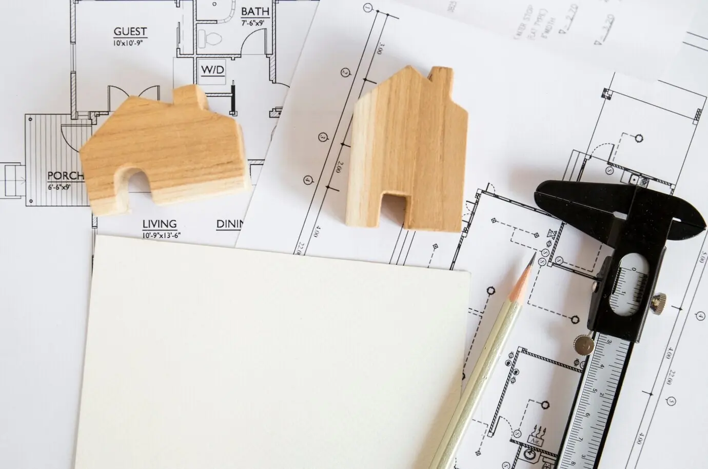 Abbildungen eines Hauses und eines Messschiebers auf Entwürfen